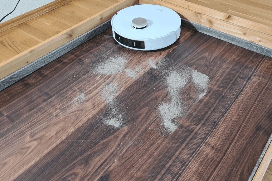 Dreame L20 Ultra убирает песок с твердого пола во время теста.